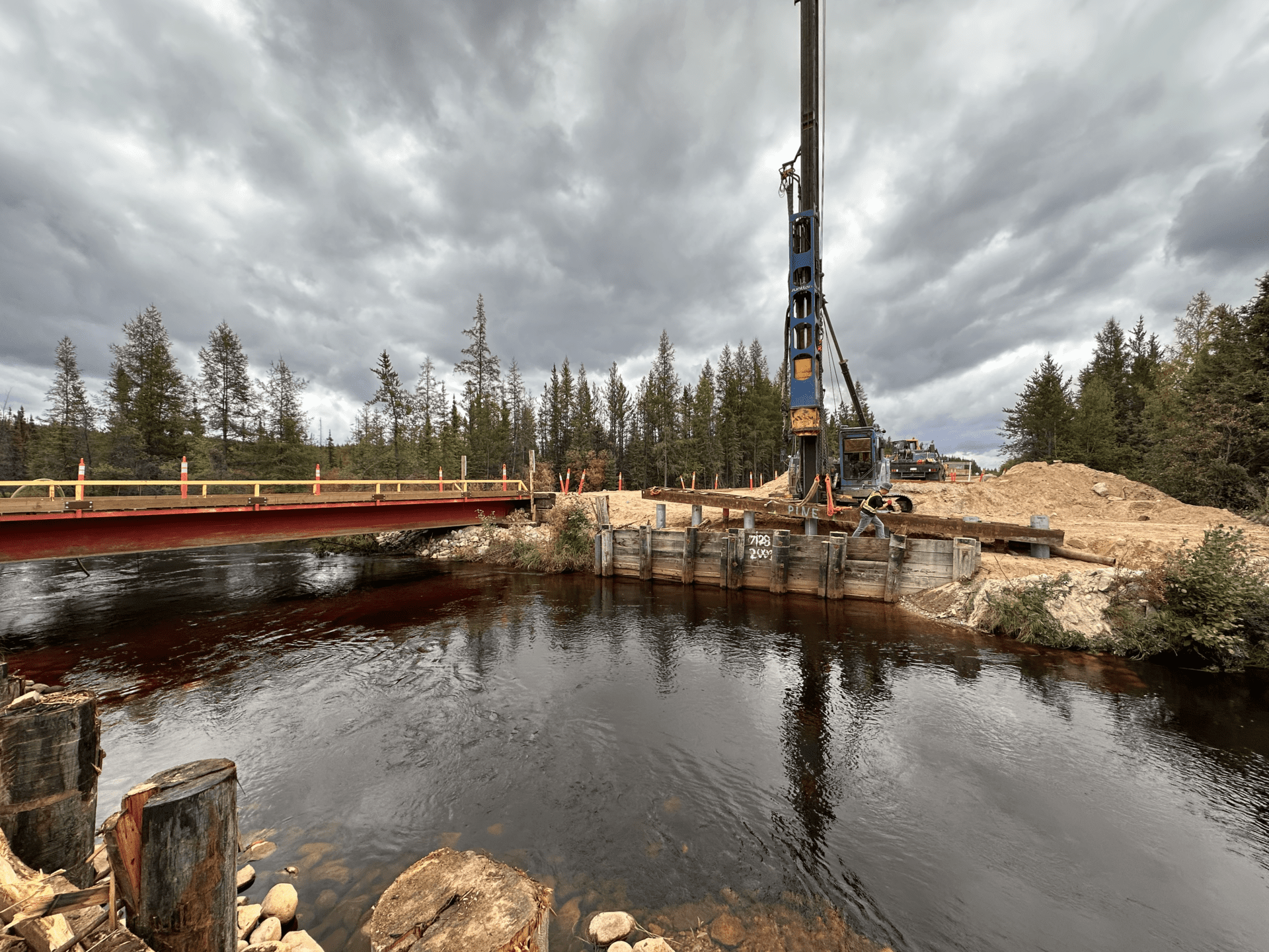 The crane is positioned close to a bridge, which is under construction