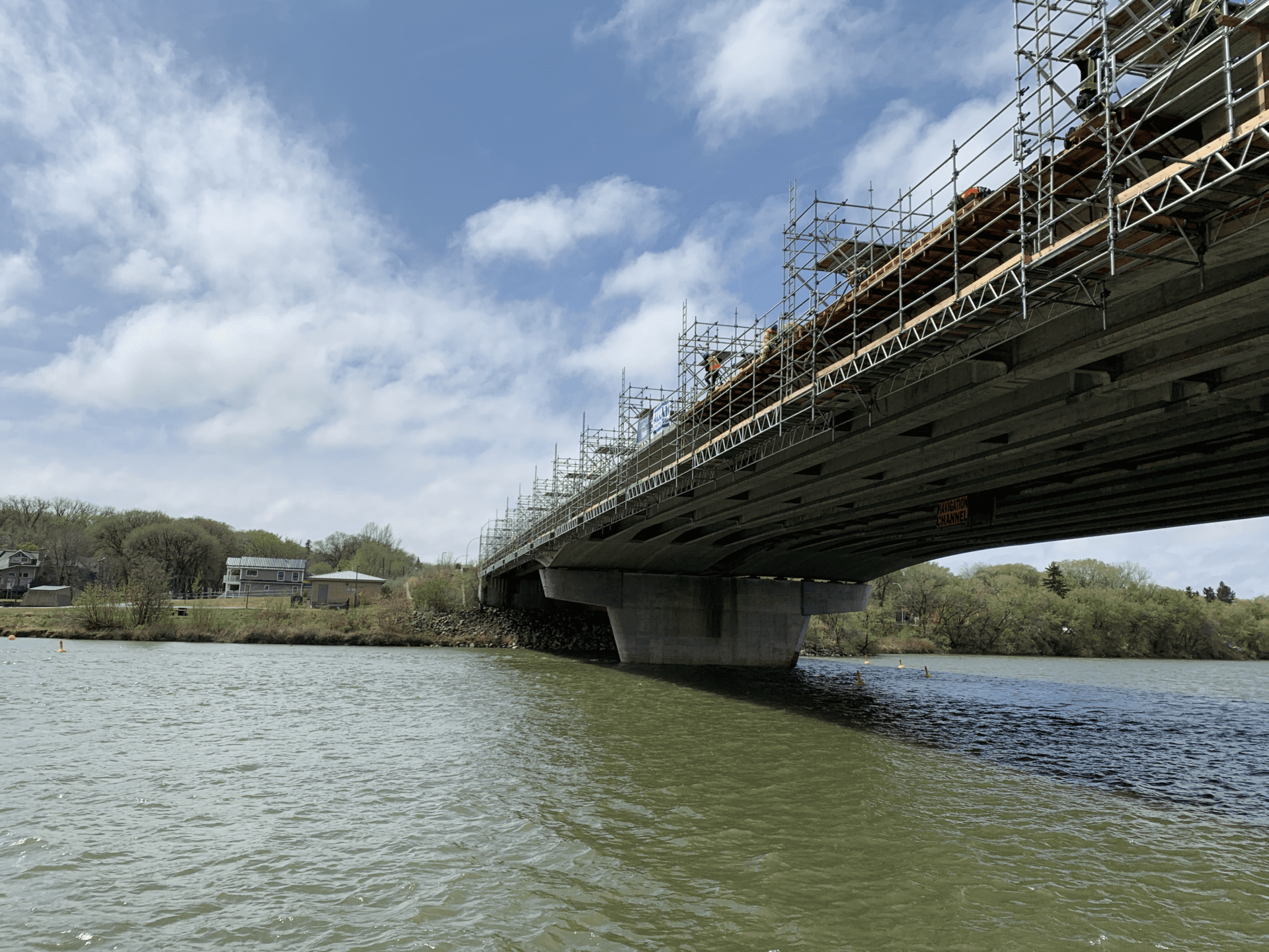 a large bridge under construction, with scaffolding and a crane visible in the background