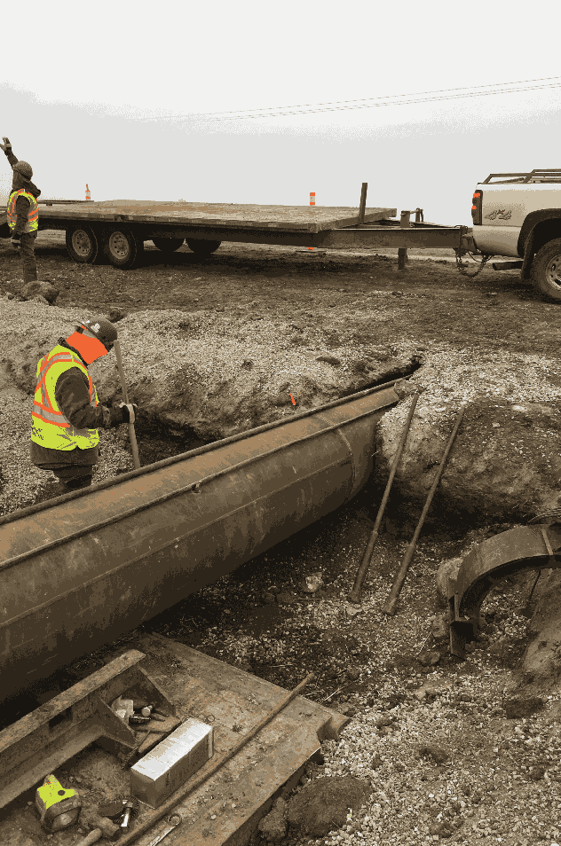 a group of construction workers working on a project in a dirt field